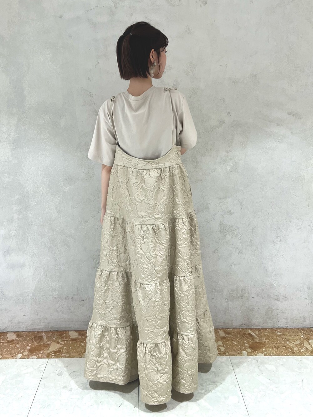 ベージュ系のTシャツ/カットソー、ベージュ系のワンピース、ホワイト系のサンダルを着用したレディースの夏コーディネートの3枚目の写真