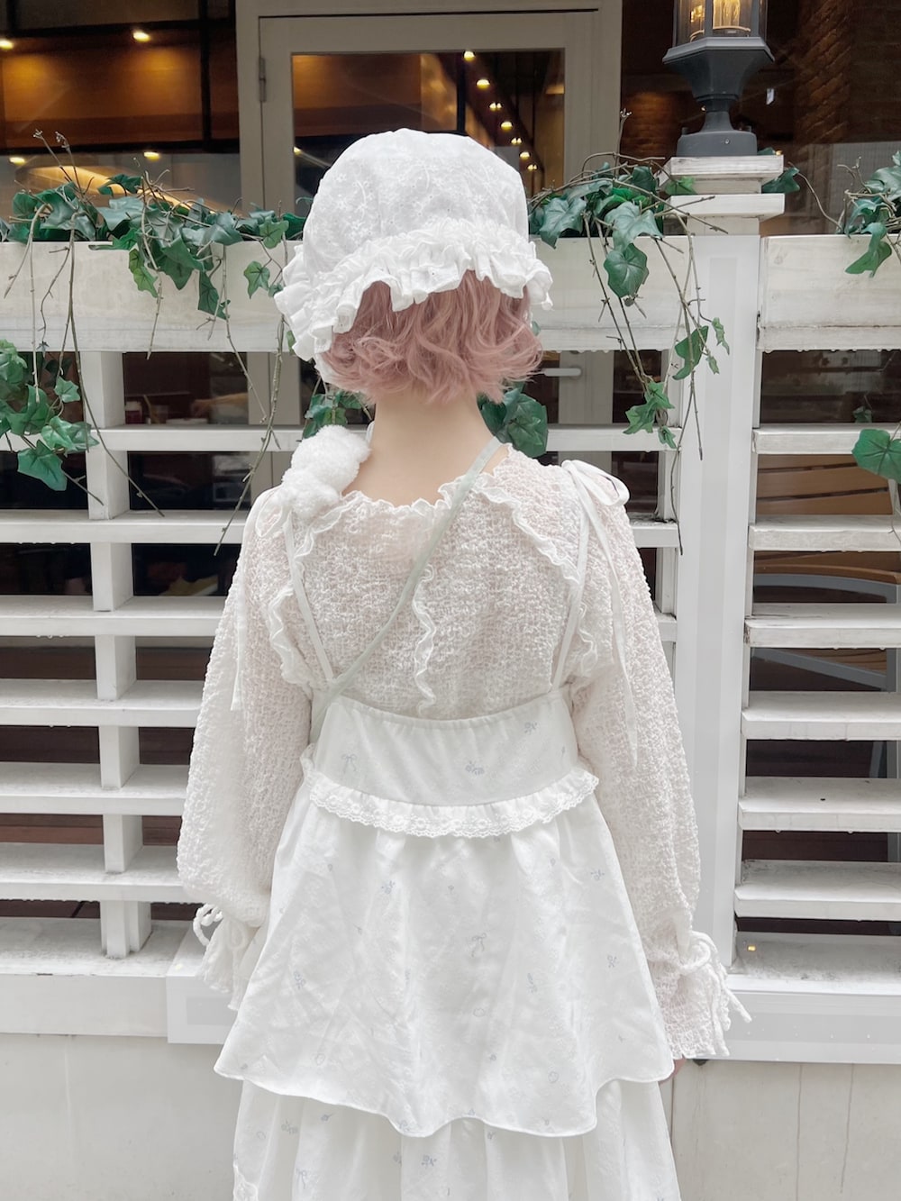 ホワイト系のTシャツ/カットソー、グリーン系のハンドバッグ、ホワイト系のワンピースを着用したレディースの冬コーディネートの8枚目の写真