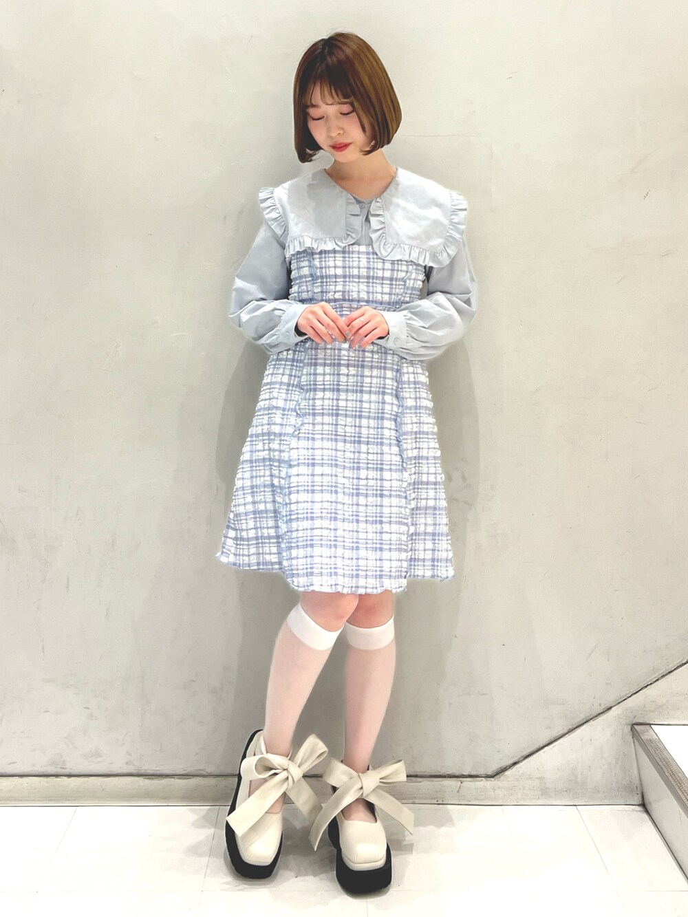 ブルー系のワンピース、ブルー系のシャツ/ブラウス、ホワイト系のパンプスを着用したレディースの春コーディネートの2枚目の写真