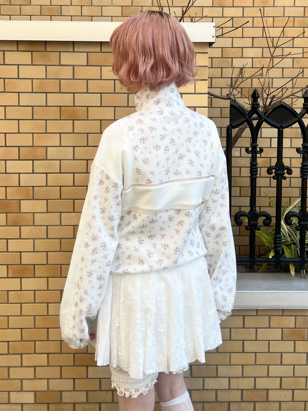 ピンク系のジャージ、ホワイト系のスカート、ホワイト系のスニーカーを着用したレディースの冬コーディネートの8枚目の写真