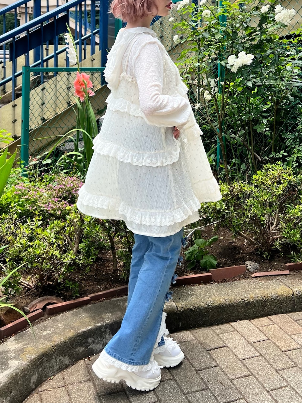 ホワイト系のチュニック、ホワイト系のTシャツ/カットソー、ブルー系のデニムパンツを着用したレディースの夏コーディネートの5枚目の写真