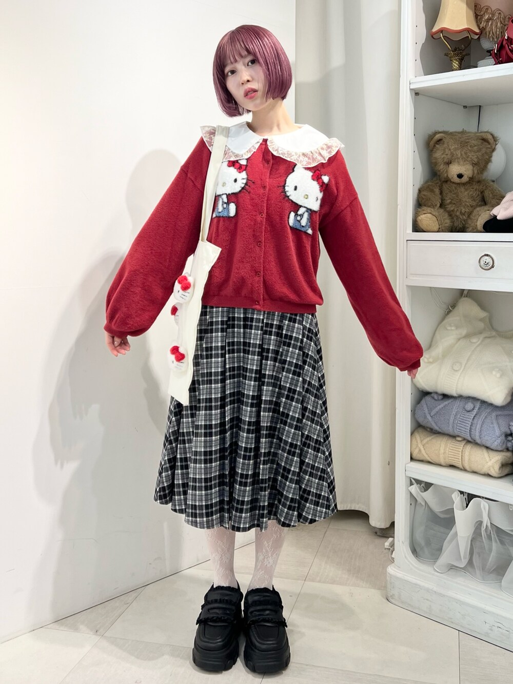 レッド系のカーディガン/ボレロ、ゴールド系のシャツ/ブラウス、ブラック系のスカートを着用したレディースの秋コーディネートの5枚目の写真