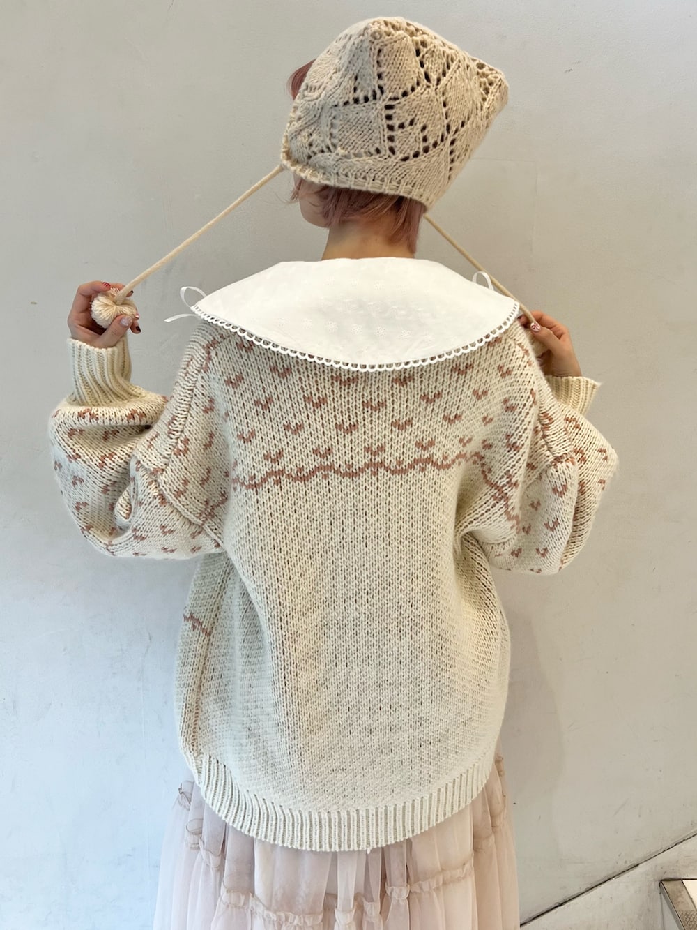 ピンク系のカーディガン/ボレロ、ホワイト系のシャツ/ブラウス、ピンク系のワンピースを着用したレディースの冬コーディネートの7枚目の写真