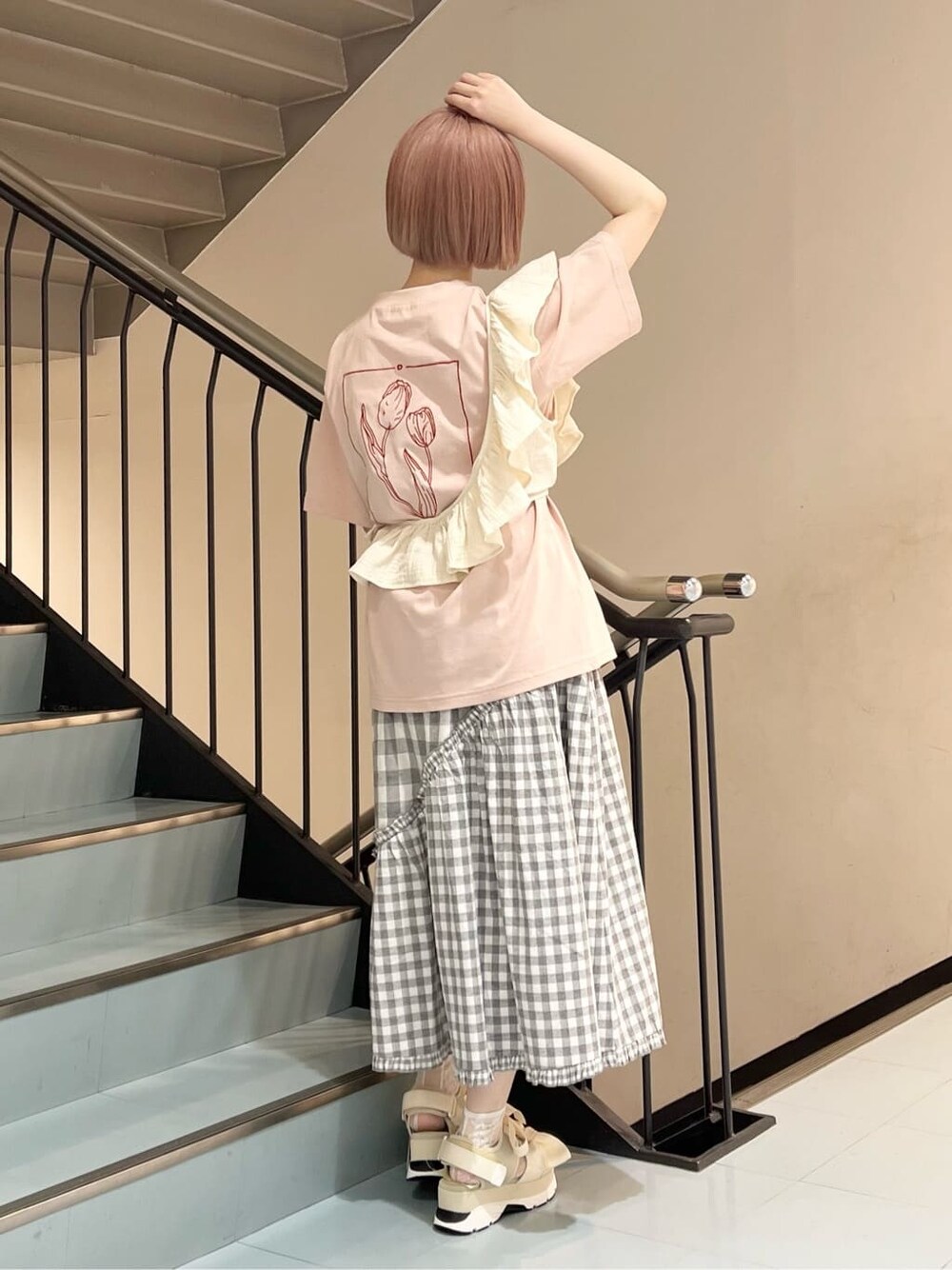 グレー系のスカート、ホワイト系のチューブトップ、ホワイト系のサンダルを着用したレディースの夏コーディネートの4枚目の写真