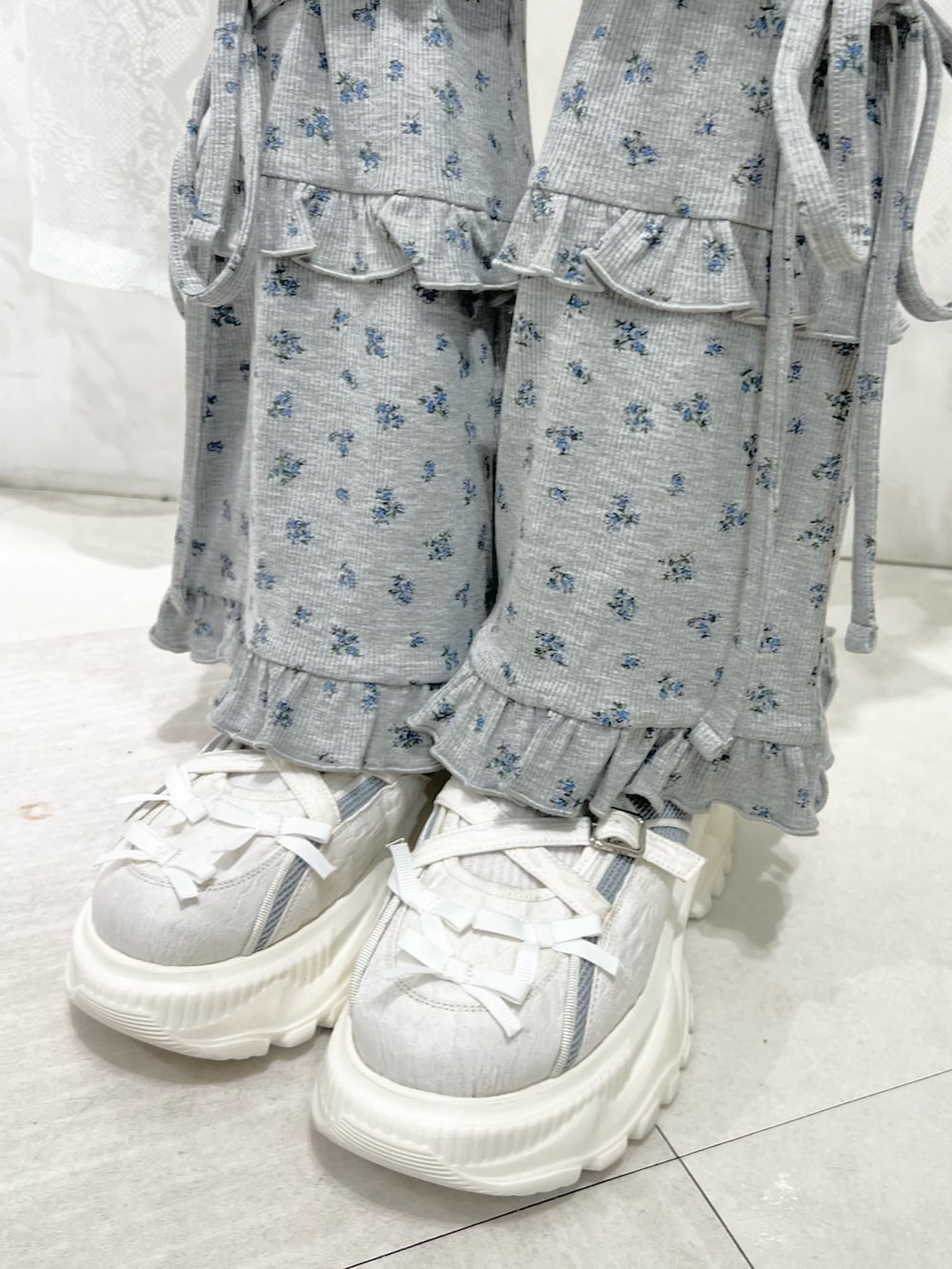 ホワイト系のスウェット、グレー系のスウェットパンツ、ブルー系のスニーカーを着用したレディースの夏コーディネートの9枚目の写真