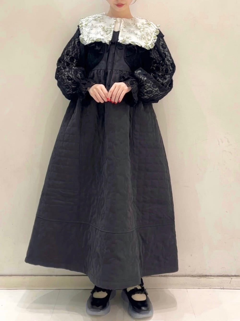 ブラック系のワンピース、ブラック系のカーディガン/ボレロ、ブラック系のスニーカーを着用したレディースの冬コーディネートの8枚目の写真