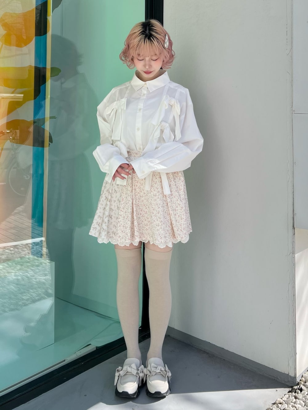 ホワイト系のシャツ/ブラウス、ピンク系のスカート、ホワイト系のスニーカーを着用したレディースの冬コーディネートの2枚目の写真