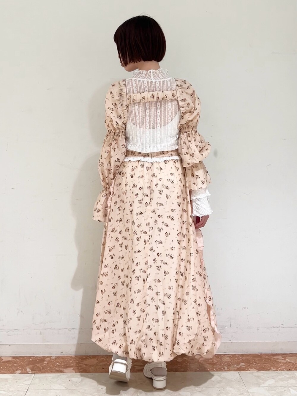 ピンク系のスカート、ピンク系のカーディガン/ボレロ、ホワイト系のパンプスを着用したレディースの春コーディネートの5枚目の写真