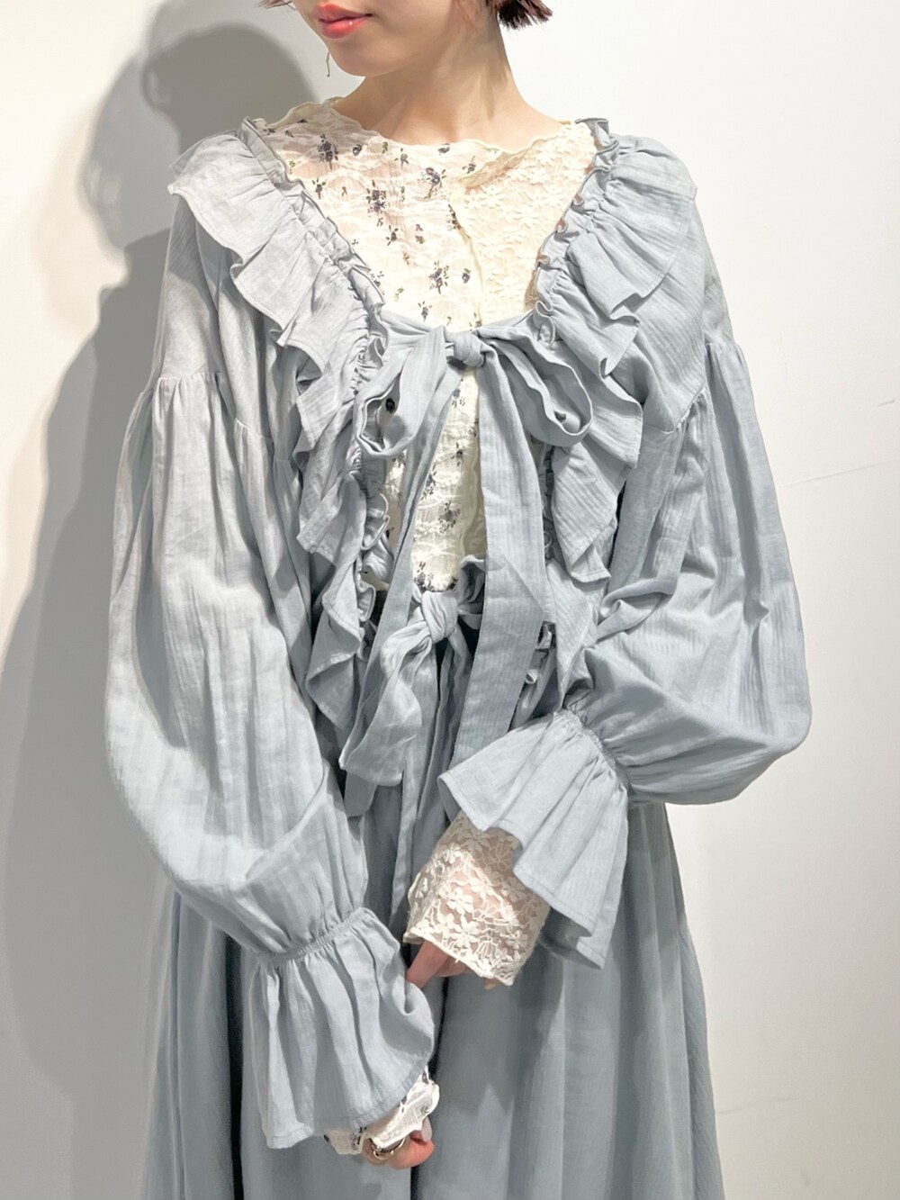 ホワイト系のTシャツ/カットソー、ホワイト系のバレエシューズ、グリーン系のワンピースを着用したレディースの冬コーディネートの7枚目の写真