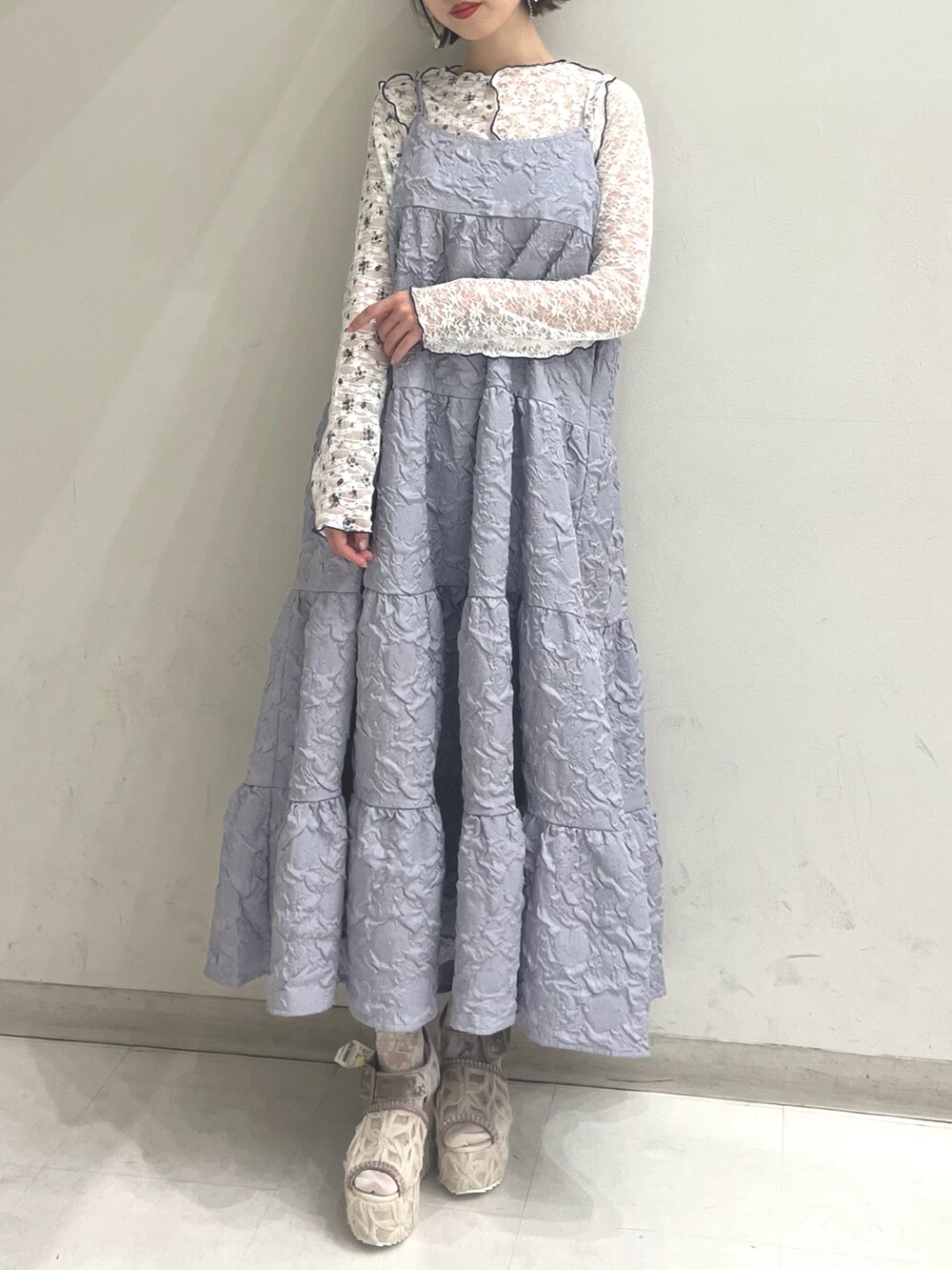 パープル系のワンピース、ホワイト系のTシャツ/カットソー、ホワイト系のサンダルを着用したレディースの夏コーディネートの6枚目の写真