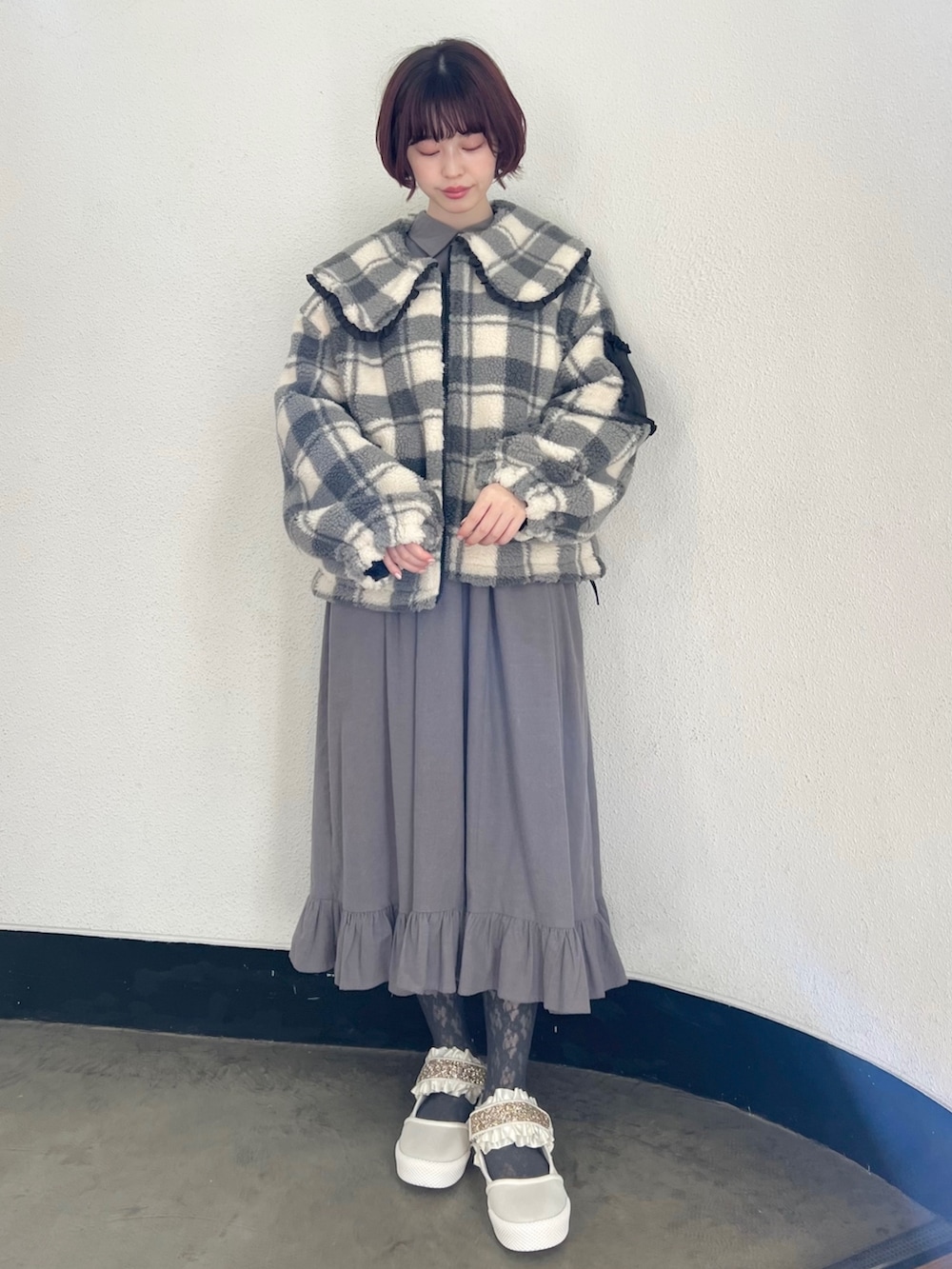 ブラック系のブルゾン、グレー系のワンピース、ホワイト系のスニーカーを着用したレディースの冬コーディネートの2枚目の写真