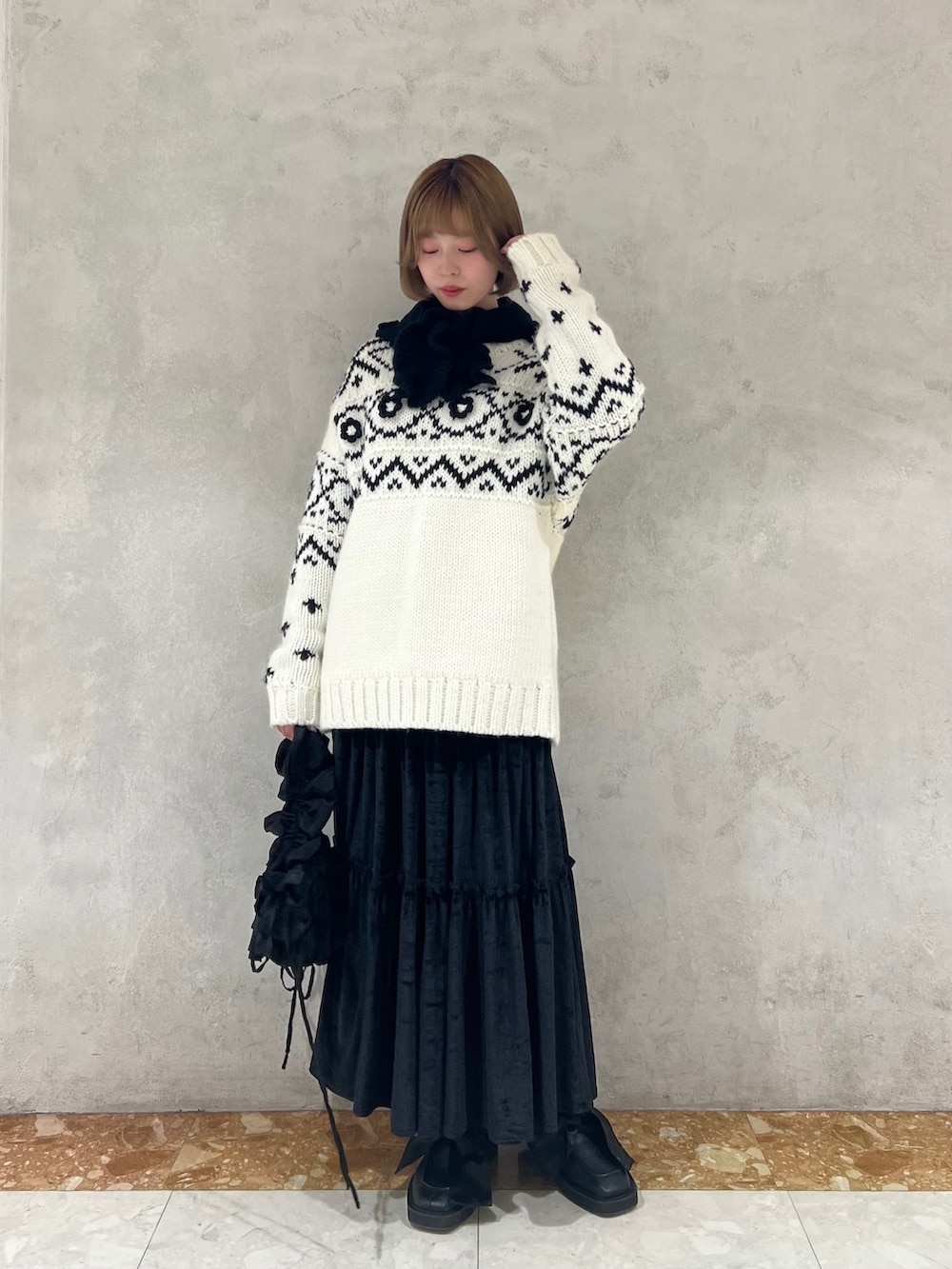 ホワイト系のニット/セーター、ブラック系のショルダーバッグ、ブラック系のモカシン/デッキシューズを着用したレディースの冬コーディネートの3枚目の写真