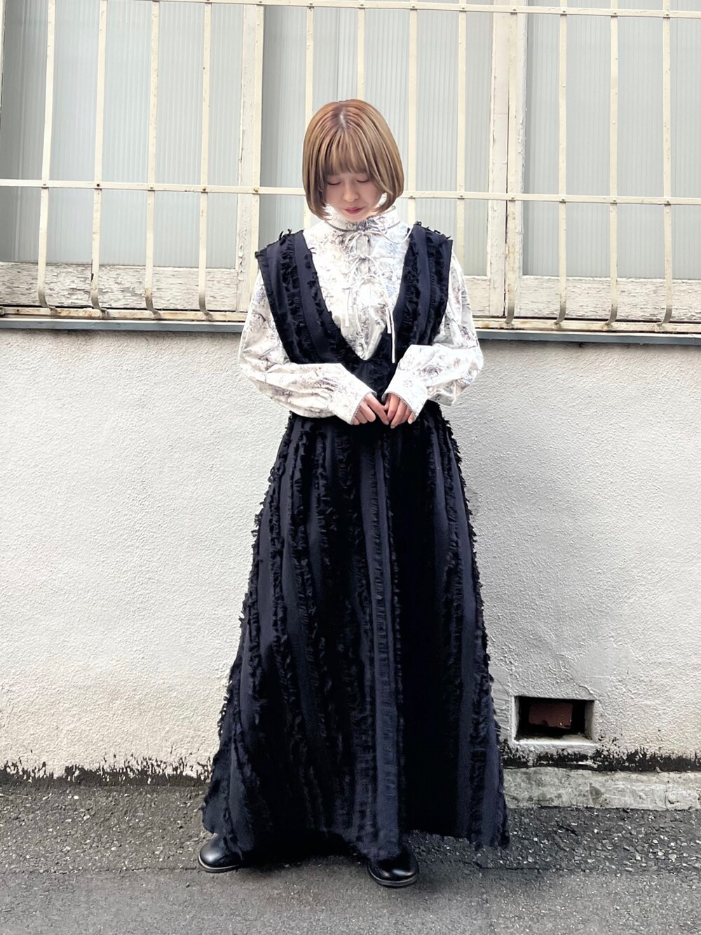 グレー系のシャツ/ブラウス、ブラック系のワンピース、ブラック系のブーツを着用したレディースの秋コーディネートの4枚目の写真