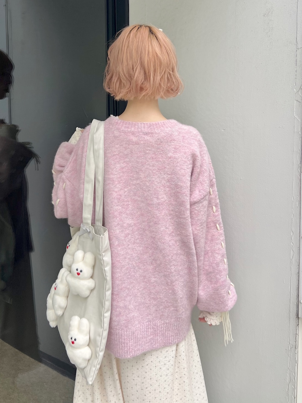 ホワイト系のブーツ、ピンク系のカーディガン/ボレロ、ホワイト系のトートバッグを着用したレディースの秋コーディネートの6枚目の写真