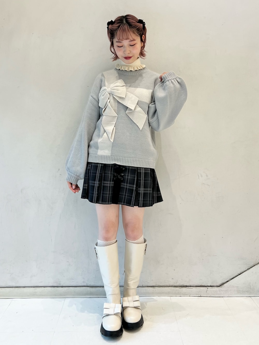 ブラック系のスカート、ブルー系のニット/セーター、ホワイト系のブーツを着用したレディースの冬コーディネートの3枚目の写真