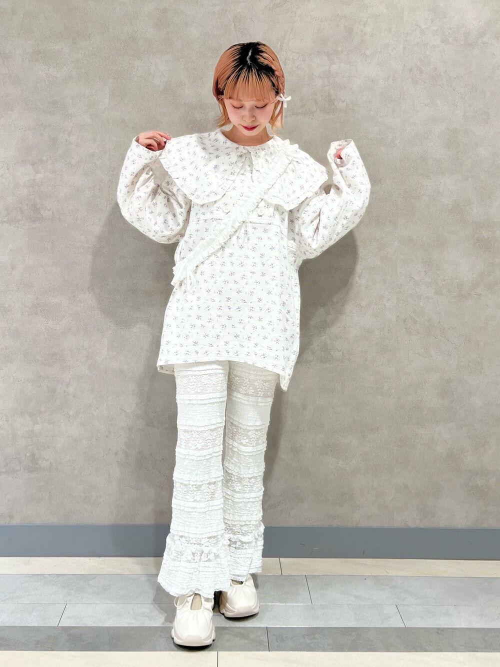 ホワイト系のデニムジャケット、ホワイト系のスラックス、ホワイト系のスニーカーを着用したレディースの秋コーディネートの2枚目の写真