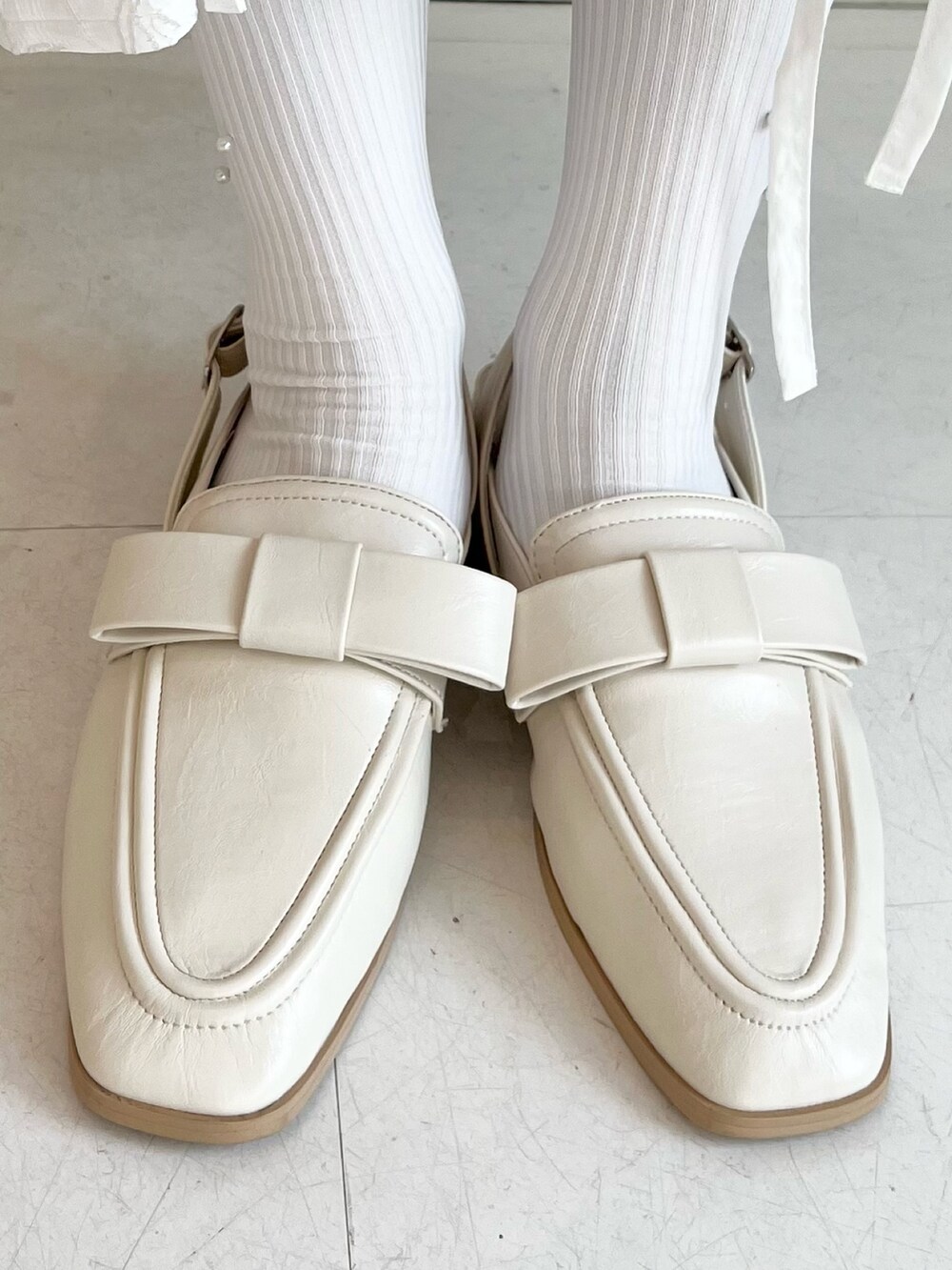 グリーン系のカーディガン/ボレロ、ホワイト系のスカート、ホワイト系のTシャツ/カットソーを着用したレディースの秋コーディネートの10枚目の写真