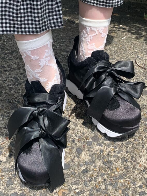 ブラック系のスニーカー、ブラック系のワンピース、ホワイト系のハンドバッグを着用したレディースの夏コーディネートの5枚目の写真