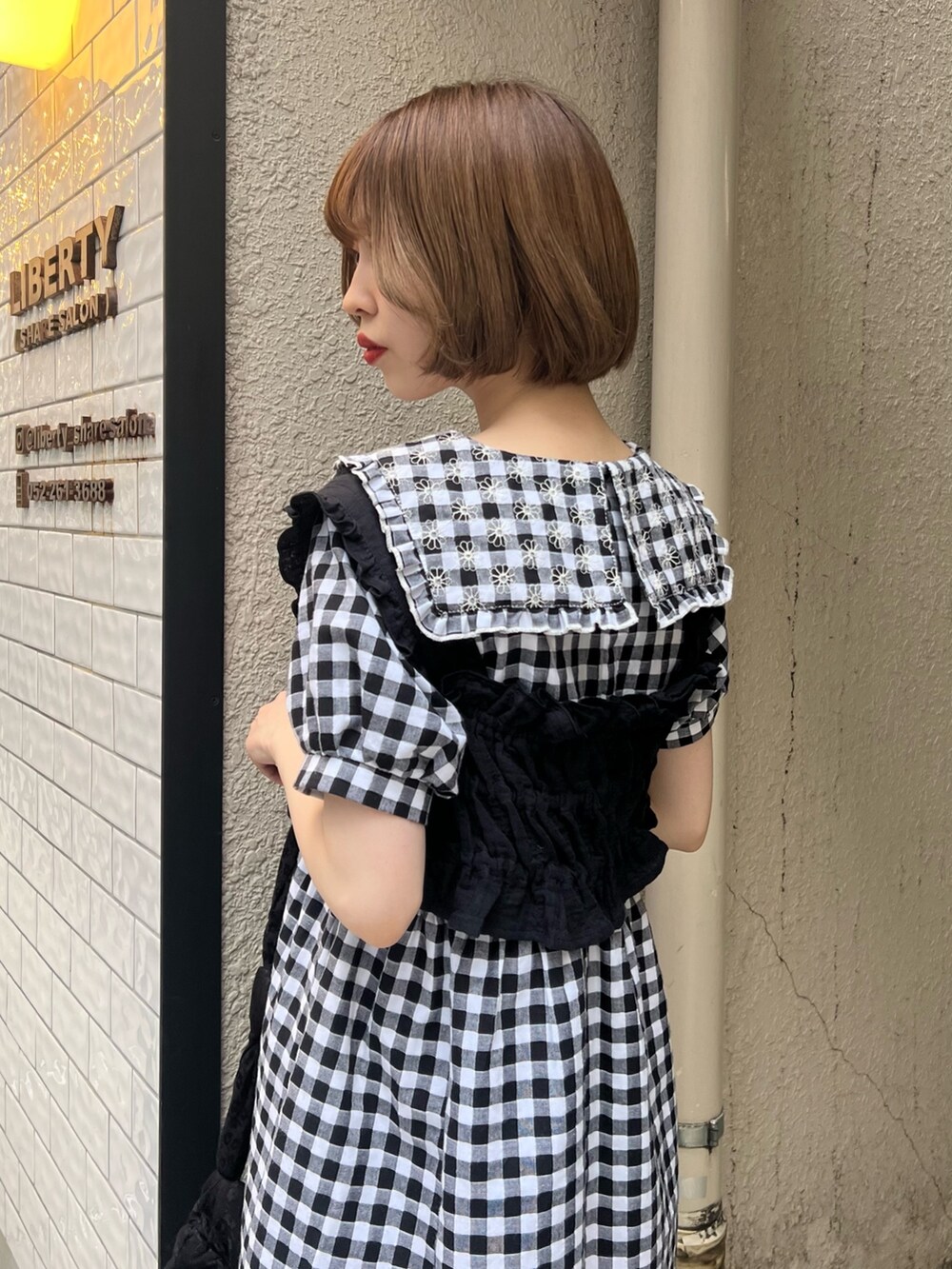 ブラック系のベスト、ブラック系のサンダル、ブラック系のワンピースを着用したレディースの夏コーディネートの7枚目の写真