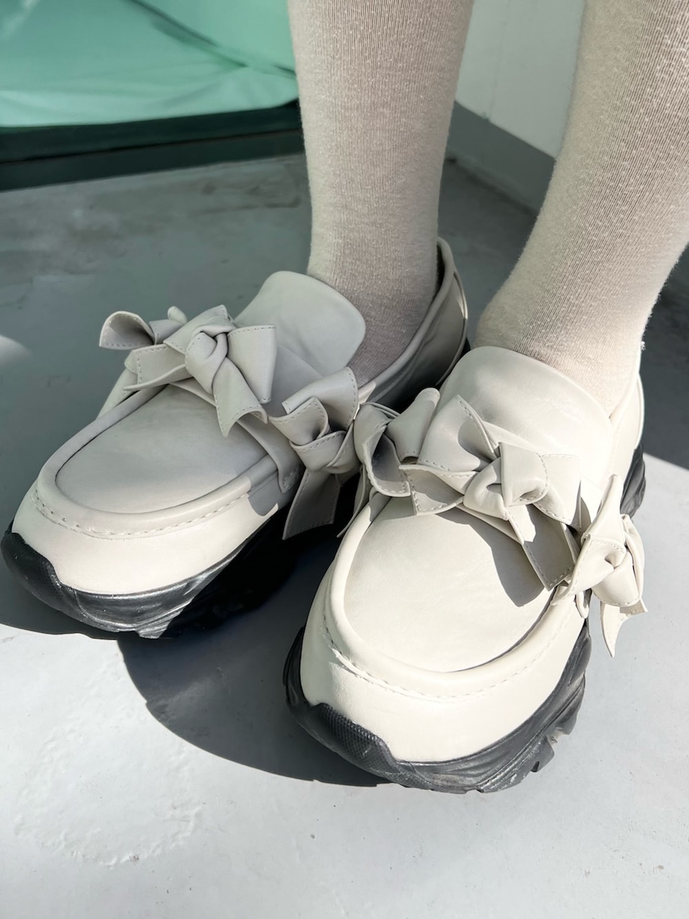 ブルー系のカーディガン/ボレロ、ピンク系のスカート、ホワイト系のスニーカーを着用したレディースの冬コーディネートの10枚目の写真