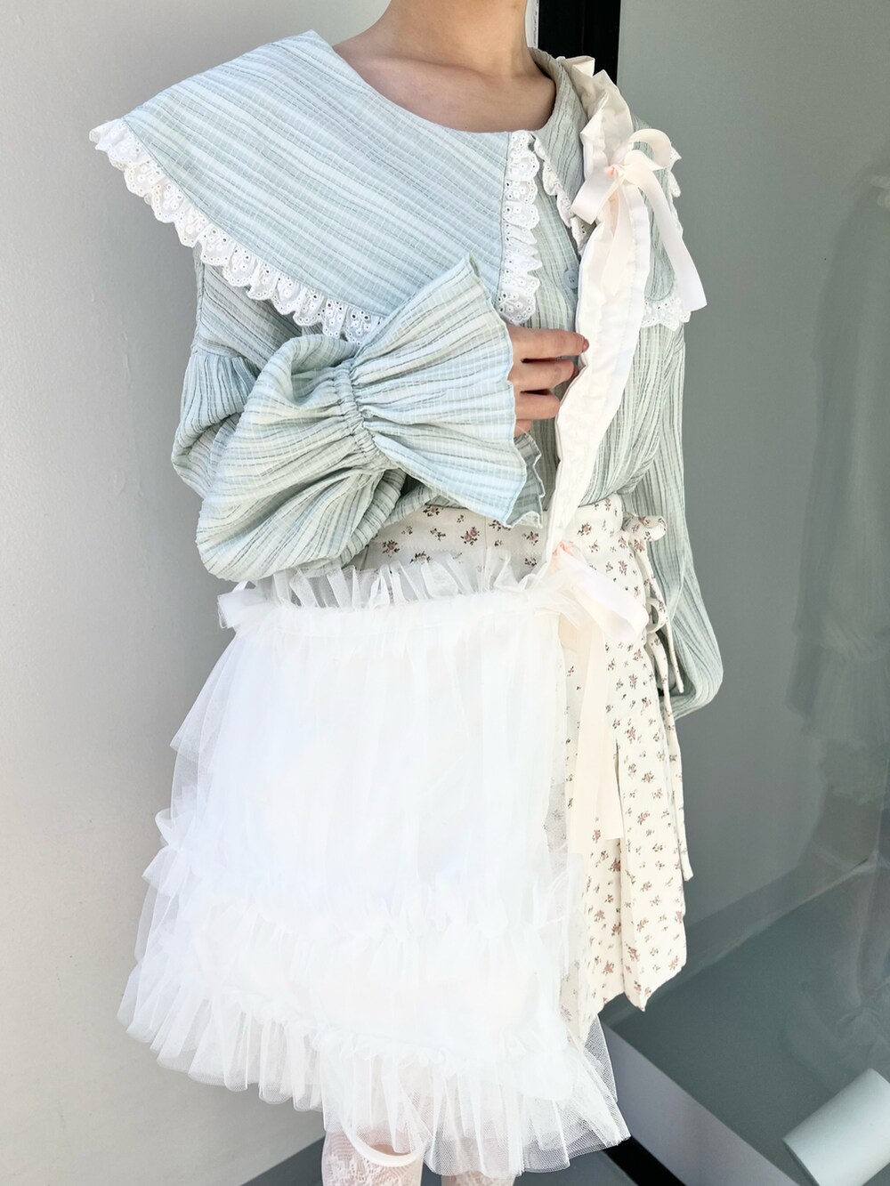 グリーン系のシャツ/ブラウス、ホワイト系のバレエシューズ、ホワイト系のトートバッグを着用したレディースの冬コーディネートの6枚目の写真