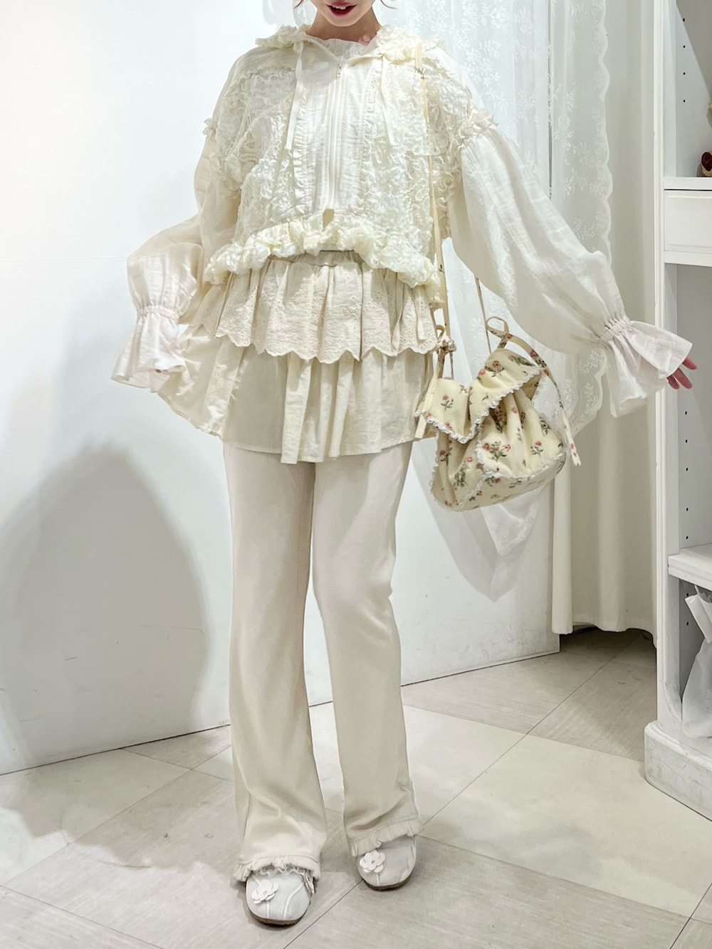 ホワイト系のスニーカー、ホワイト系のスウェットパンツ、ホワイト系のショルダーバッグを着用したレディースの冬コーディネートの3枚目の写真