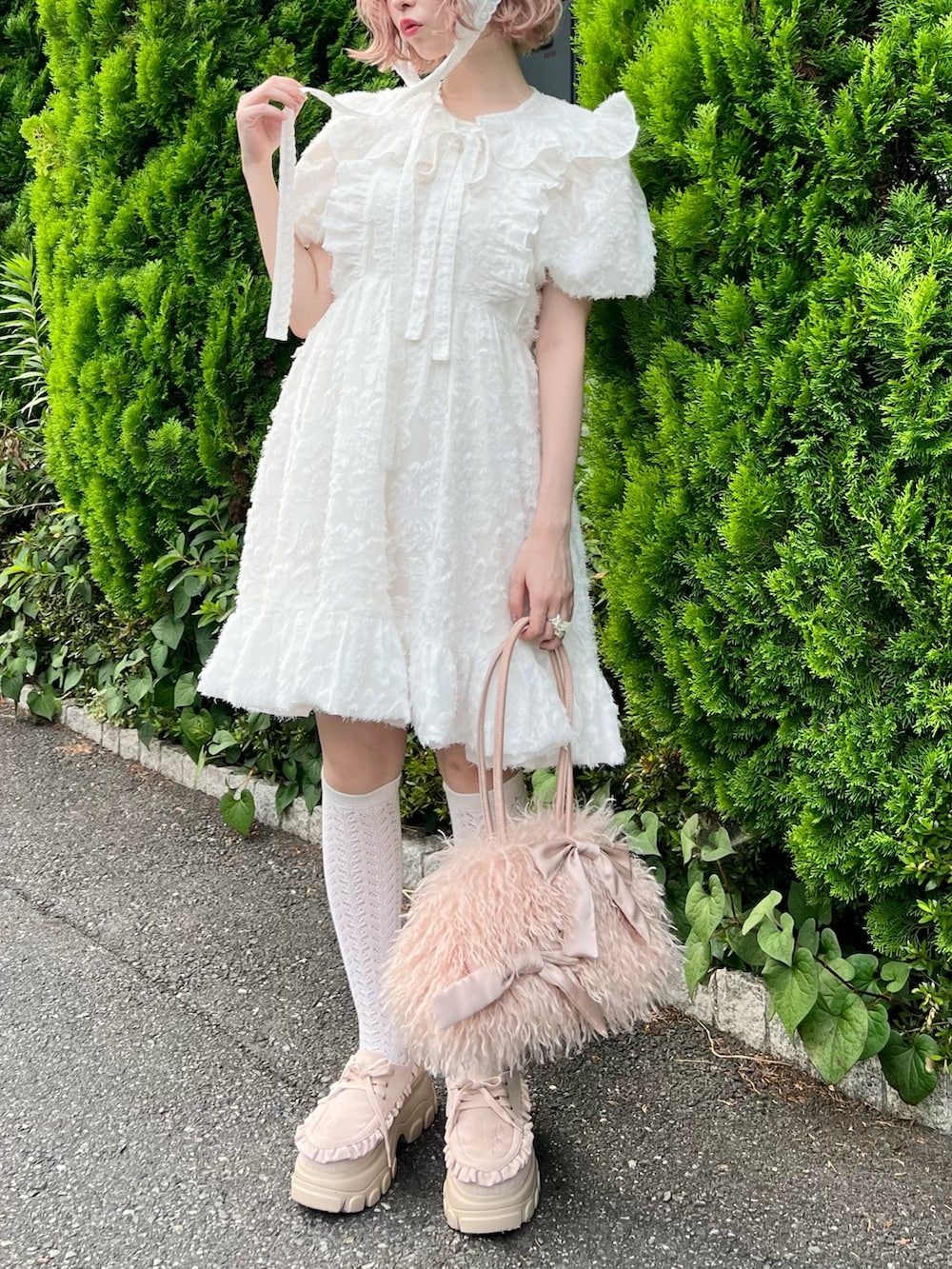 ホワイト系のワンピース、ピンク系のボストンバッグ、ピンク系のローファーを着用したレディースの夏コーディネートの4枚目の写真