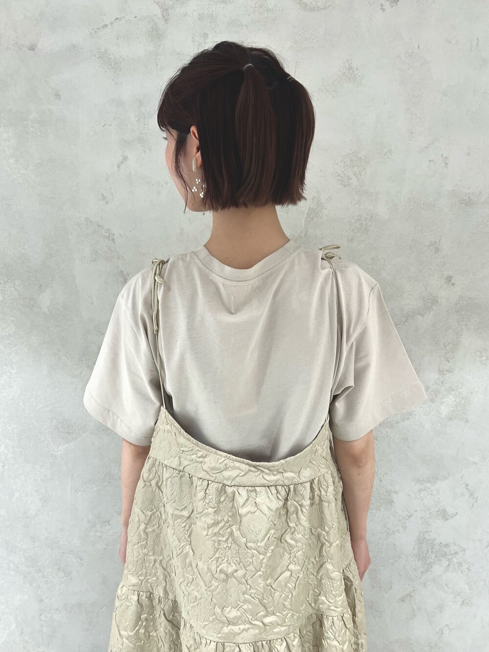 ベージュ系のTシャツ/カットソー、ベージュ系のワンピース、ホワイト系のサンダルを着用したレディースの夏コーディネートの8枚目の写真