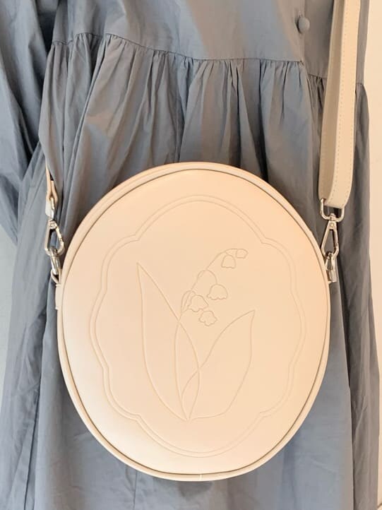 ベージュ系のカーディガン/ボレロ、ホワイト系のスニーカー、ホワイト系のショルダーバッグを着用したレディースの冬コーディネートの9枚目の写真