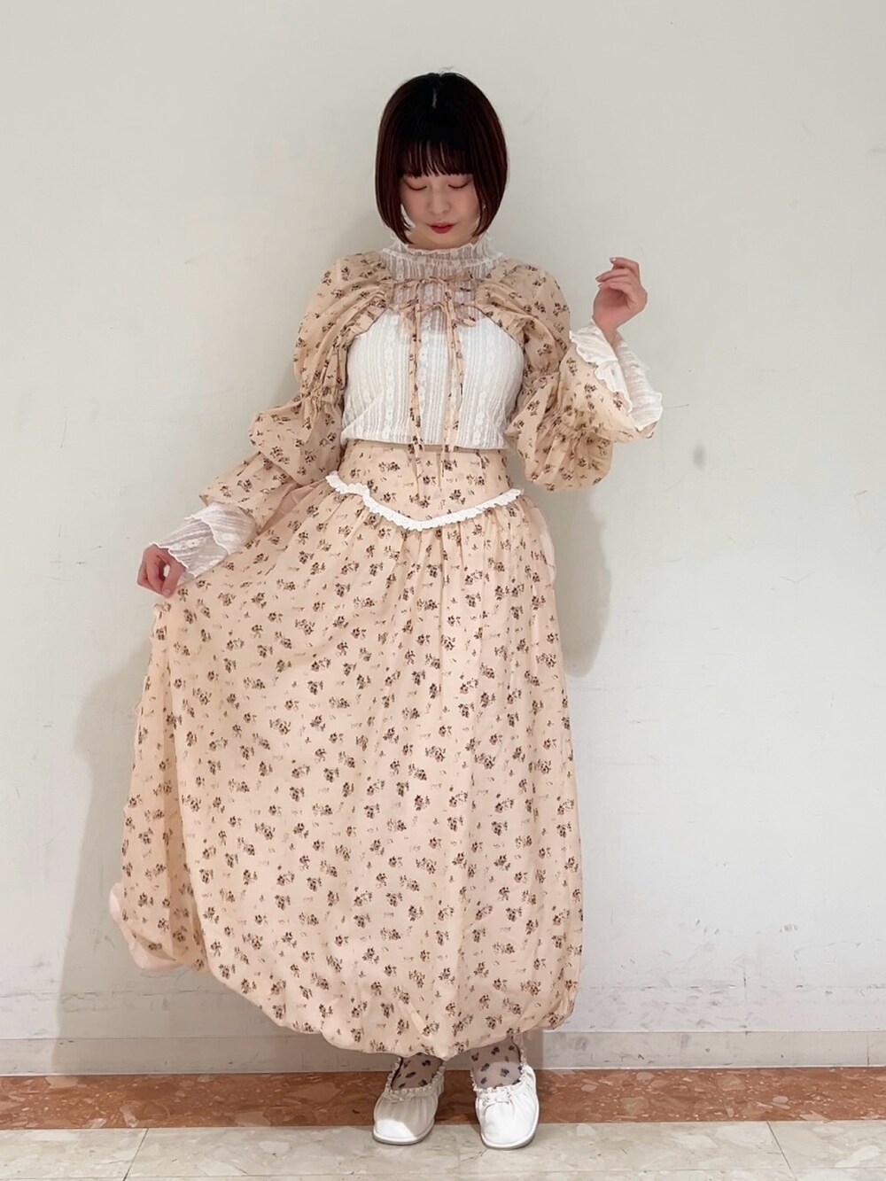 ピンク系のスカート、ピンク系のカーディガン/ボレロ、ホワイト系のパンプスを着用したレディースの春コーディネートの3枚目の写真