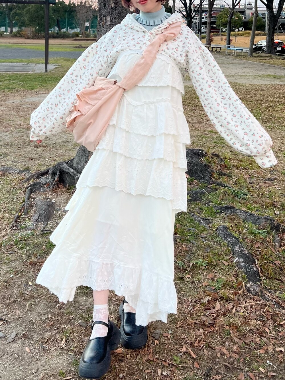 ホワイト系のワンピース、その他のカーディガン/ボレロ、ピンク系のショルダーバッグを着用したレディースの冬コーディネートの7枚目の写真