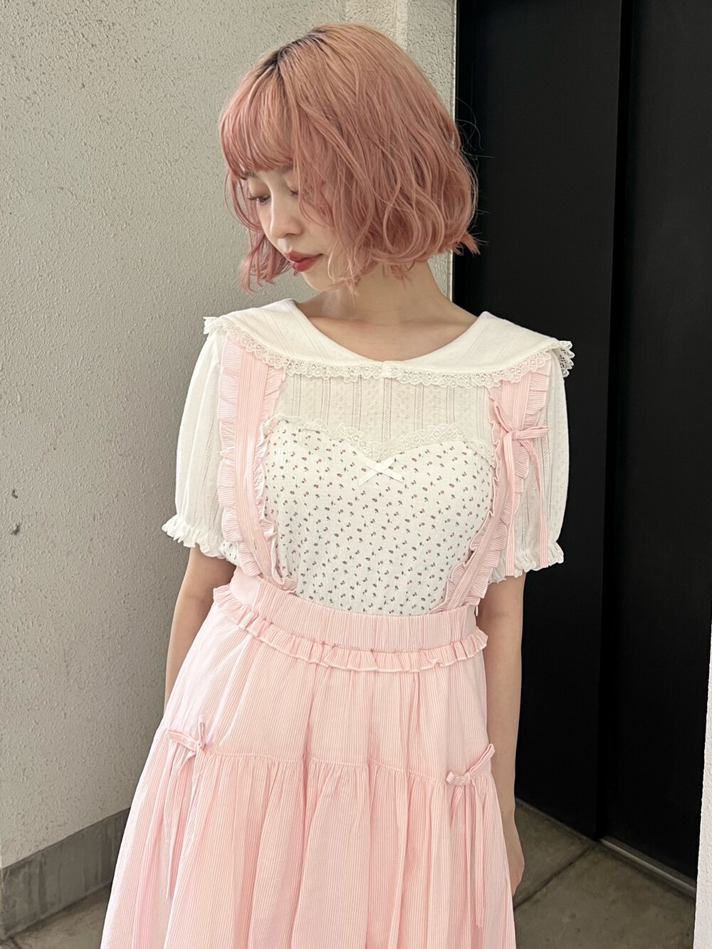 ホワイト系のTシャツ/カットソー、ピンク系のジャンパースカート、ホワイト系のサンダルを着用したレディースの夏コーディネートの8枚目の写真