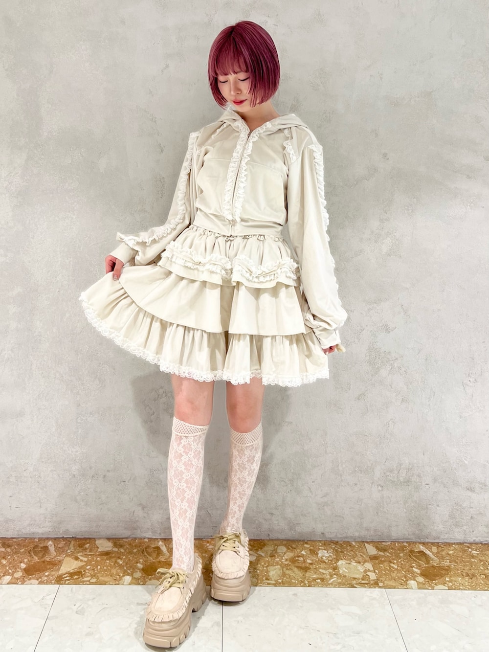 ホワイト系のスカート、ホワイト系のパーカー、ベージュ系のローファーを着用したレディースの秋コーディネートの3枚目の写真