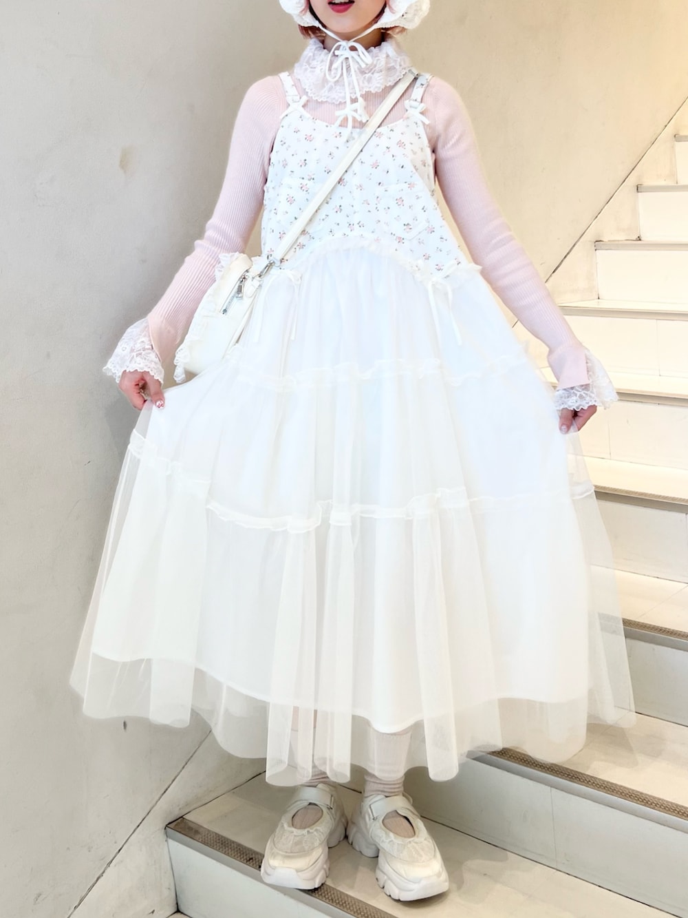 ホワイト系のワンピース、ピンク系のニット/セーター、ホワイト系のスニーカーを着用したレディースの冬コーディネートの3枚目の写真