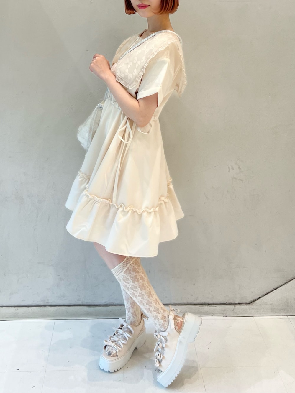 ピンク系のワンピース、ホワイト系のショルダーバッグ、ホワイト系のサンダルを着用したレディースの夏コーディネートの3枚目の写真