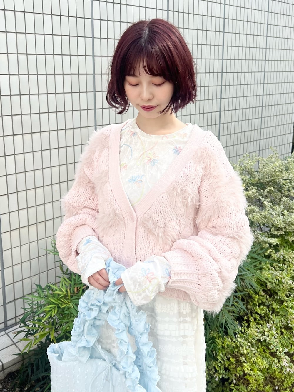 ホワイト系のスカート、ホワイト系のTシャツ/カットソー、ピンク系のスニーカーを着用したレディースの秋コーディネートの4枚目の写真