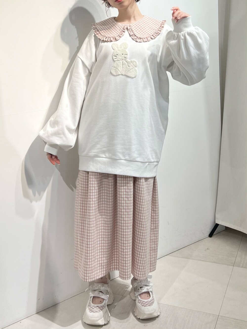 ホワイト系のショルダーバッグ、ピンク系のワンピース、ホワイト系のスウェットを着用したレディースの冬コーディネートの5枚目の写真