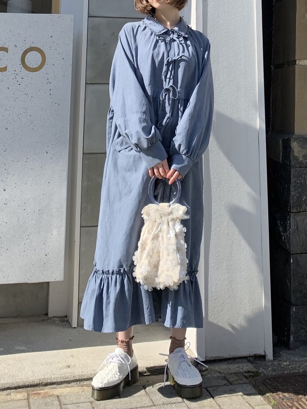 ブルー系のワンピース、ホワイト系のその他シューズ、ホワイト系のハンドバッグを着用したレディースの冬コーディネートの3枚目の写真