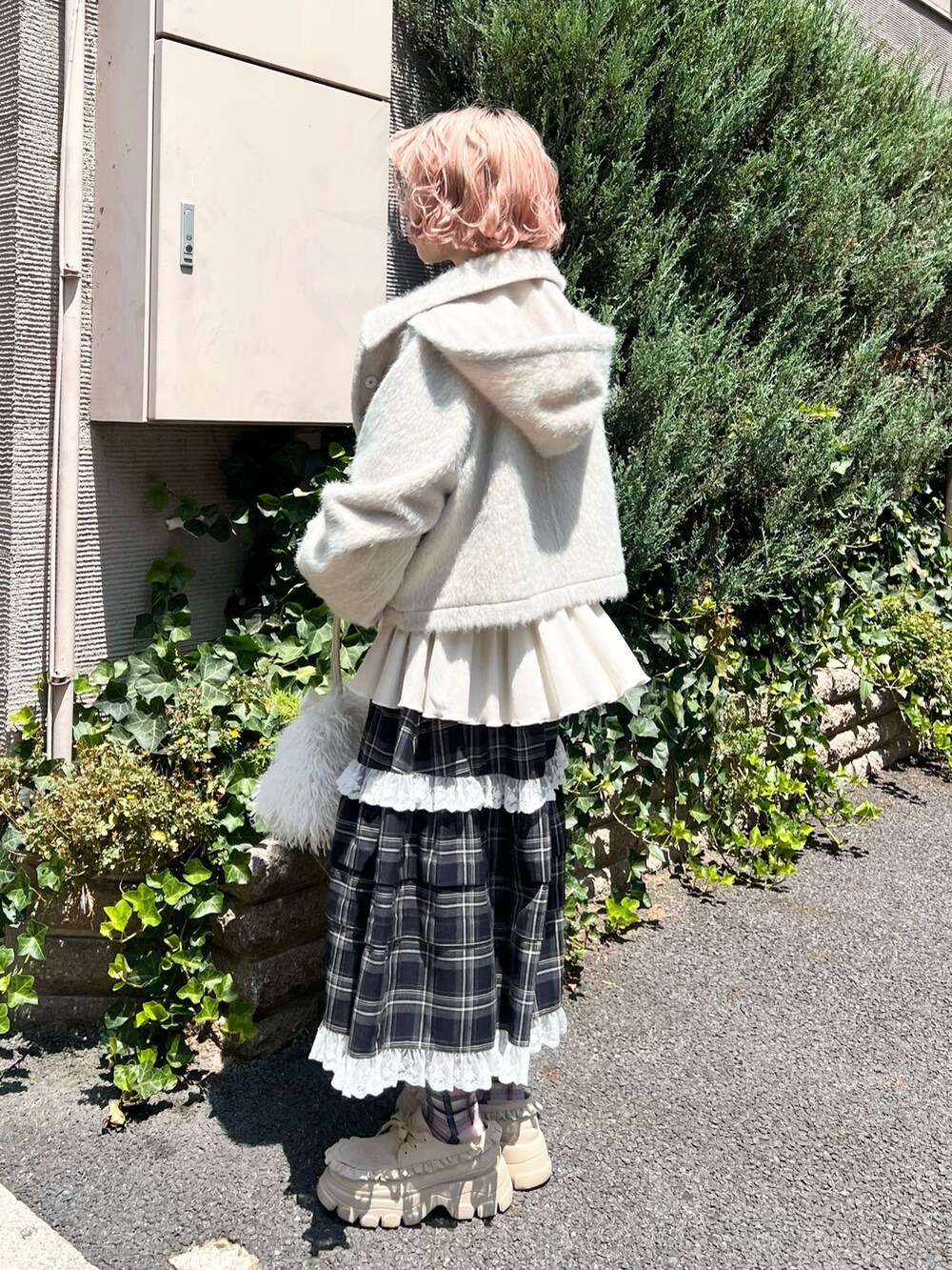 グリーン系のダッフルコート、ブルー系のスカート、ベージュ系のローファーを着用したレディースの夏コーディネートの8枚目の写真