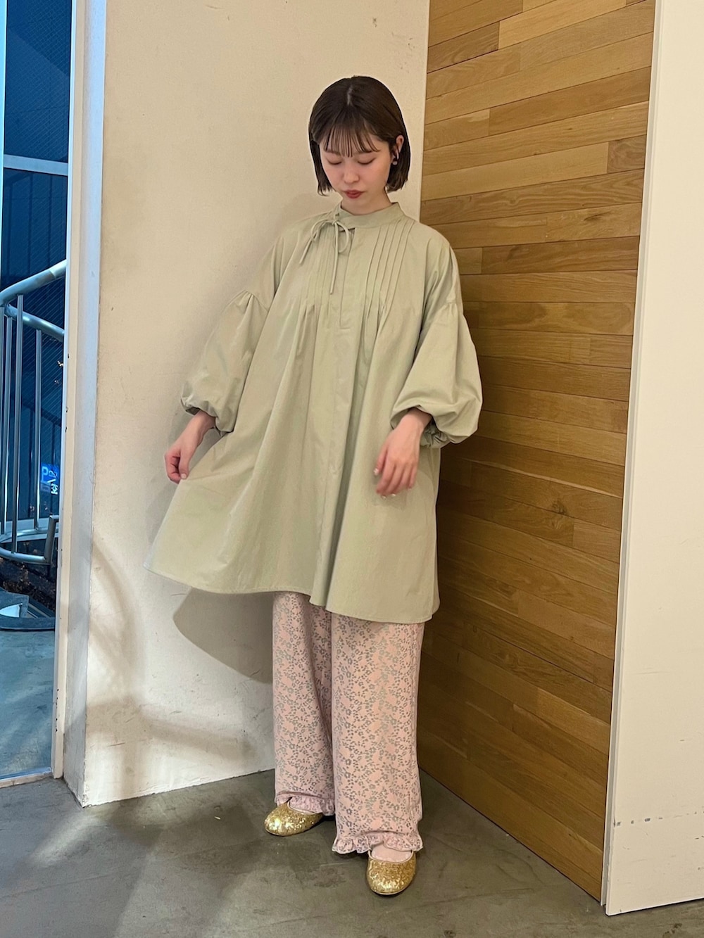 ピンク系のその他パンツ、ゴールド系のパンプス、グリーン系のワンピースを着用したレディースの春コーディネートの2枚目の写真