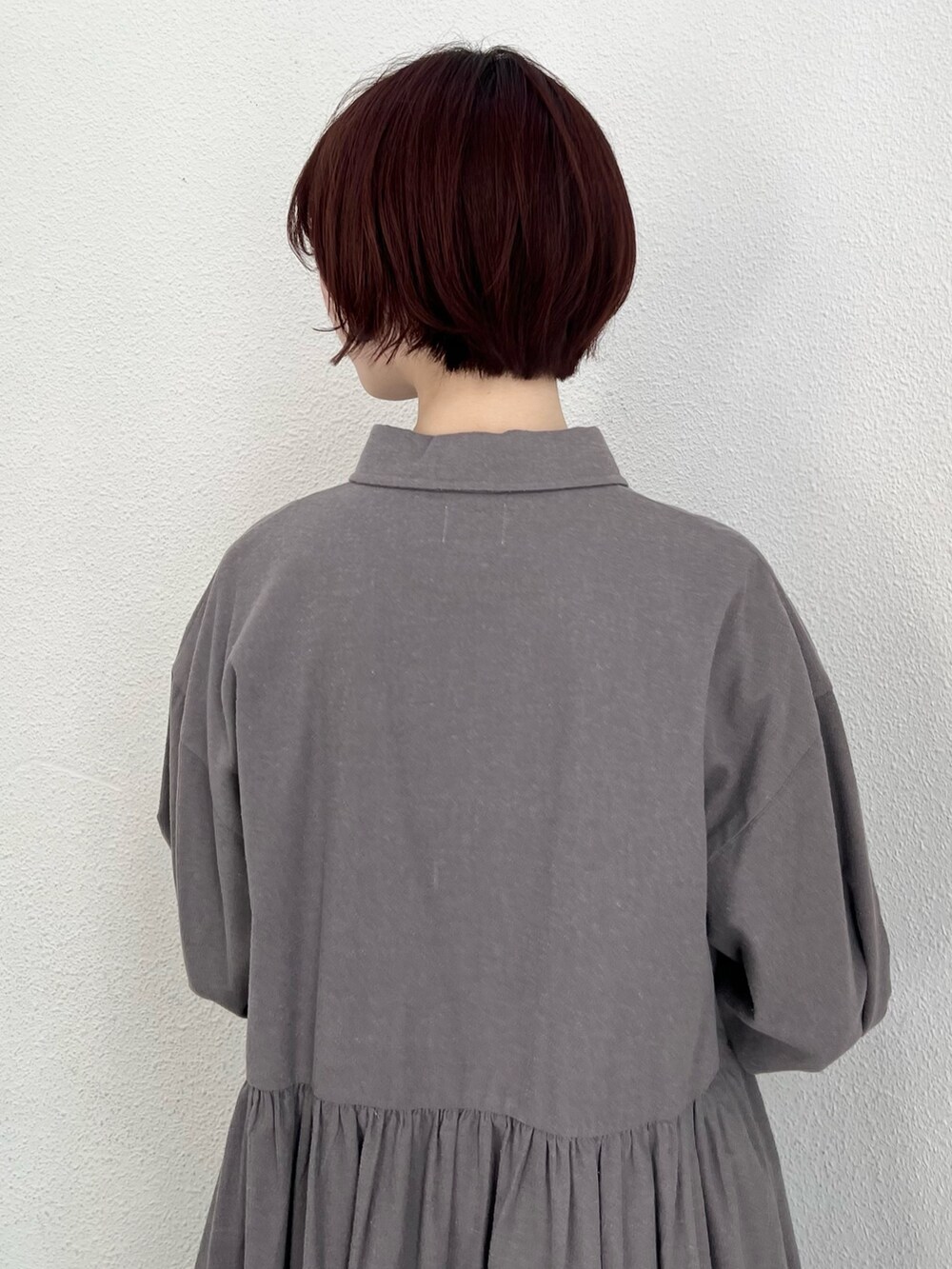 ブラック系のブルゾン、グレー系のワンピース、ホワイト系のスニーカーを着用したレディースの冬コーディネートの8枚目の写真