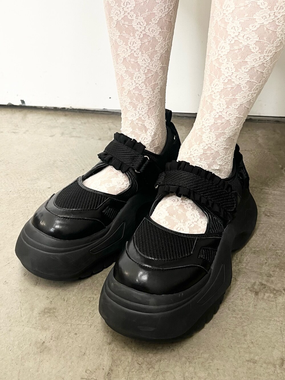 ブラック系のチェスターコート、ホワイト系のニット/セーター、ブラック系のハンドバッグを着用したレディースの秋コーディネートの9枚目の写真