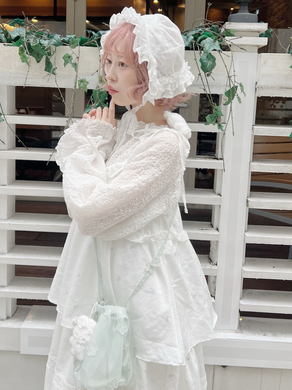 ホワイト系のTシャツ/カットソー、グリーン系のハンドバッグ、ホワイト系のワンピースを着用したレディースの冬コーディネートの6枚目の写真