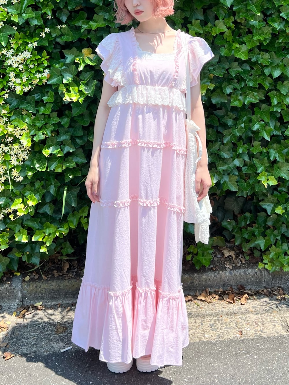 ピンク系のワンピース、ピンク系のキャミソール、ホワイト系のトートバッグを着用したレディースの夏コーディネートの6枚目の写真