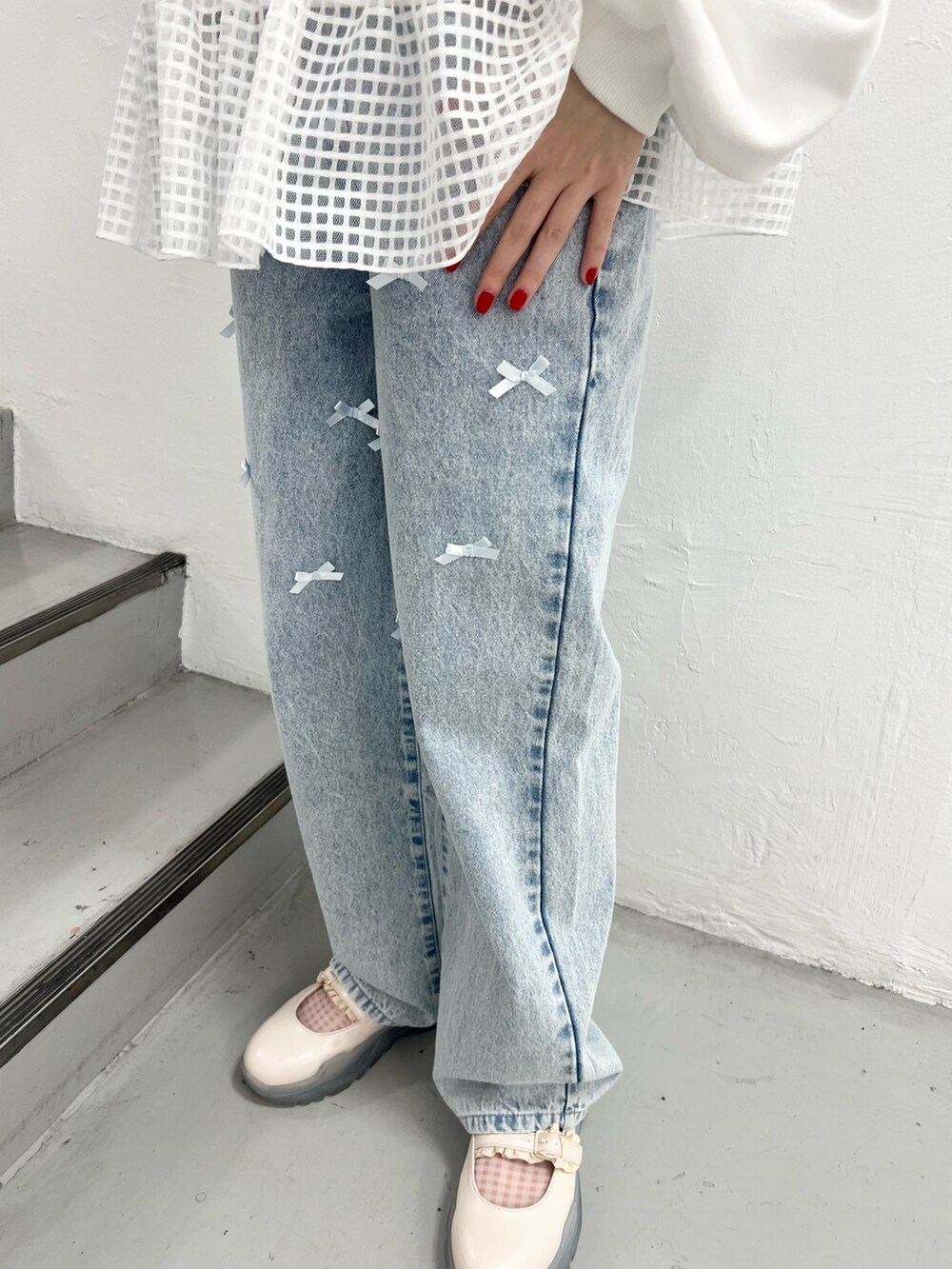 ホワイト系のスウェット、ブルー系のデニムパンツ、ホワイト系のスニーカーを着用したレディースの春コーディネートの9枚目の写真