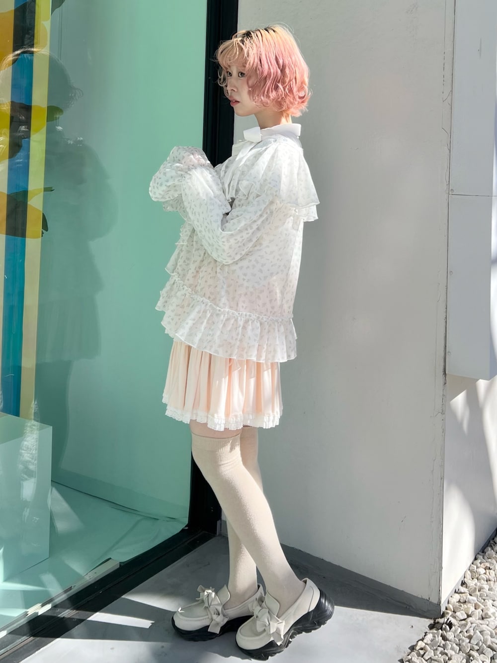 ブルー系のカーディガン/ボレロ、ピンク系のスカート、ホワイト系のスニーカーを着用したレディースの冬コーディネートの4枚目の写真