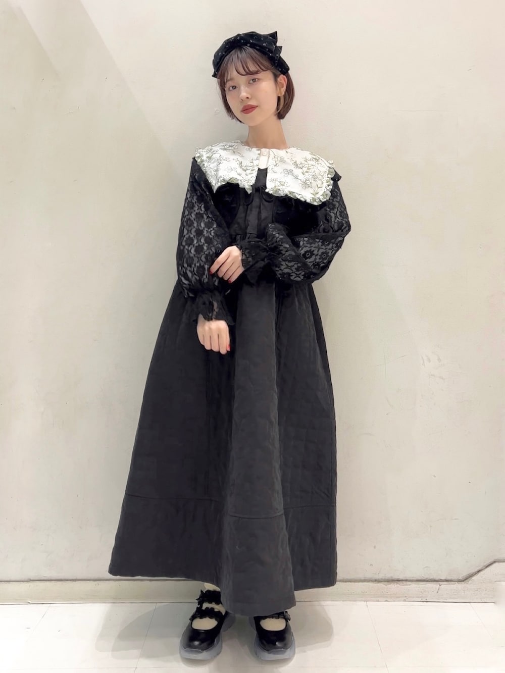 ブラック系のワンピース、ブラック系のカーディガン/ボレロ、ブラック系のスニーカーを着用したレディースの冬コーディネートの2枚目の写真