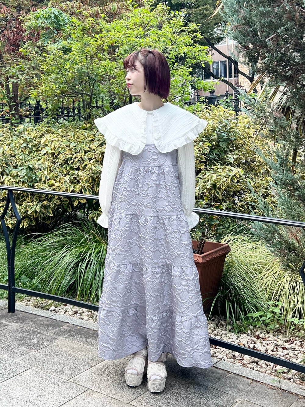 ホワイト系のシャツ/ブラウス、パープル系のワンピース、ホワイト系のサンダルを着用したレディースの秋コーディネートの4枚目の写真