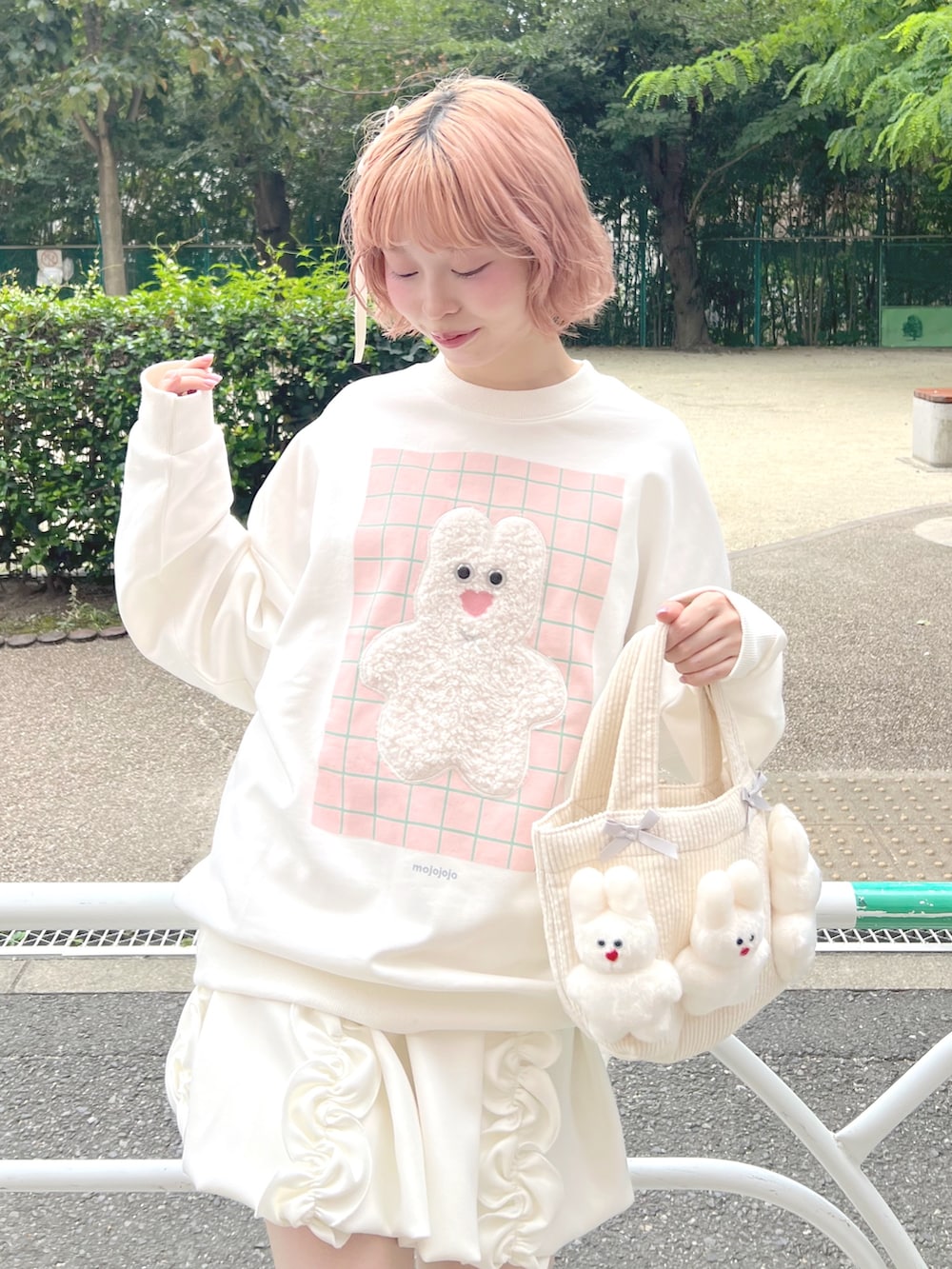 ホワイト系のスカート、ピンク系のブーツ、ホワイト系のスウェットを着用したレディースの秋コーディネートの4枚目の写真