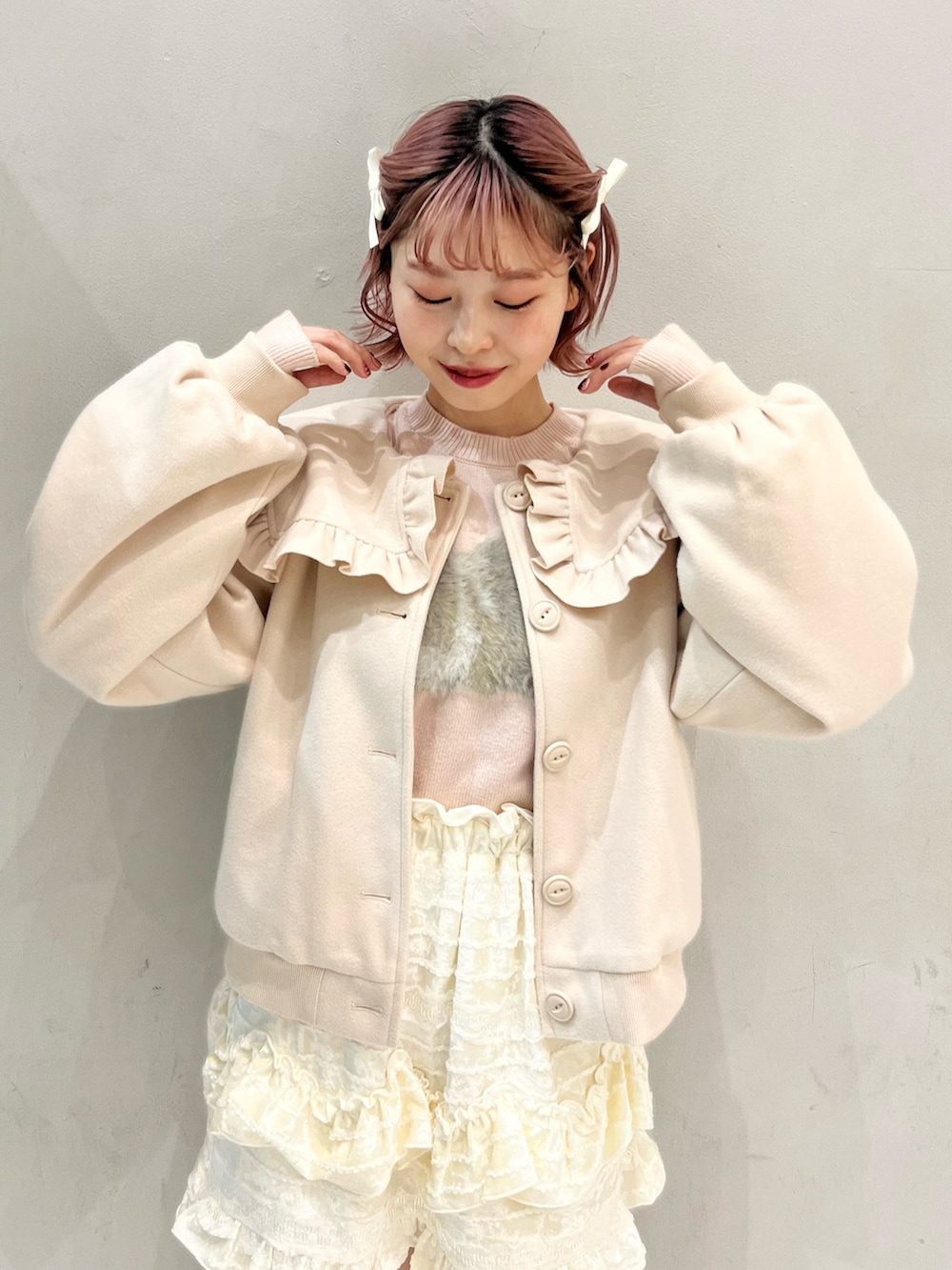 ホワイト系のブルゾン、ピンク系のショルダーバッグ、ホワイト系のスカートを着用したレディースの冬コーディネートの2枚目の写真